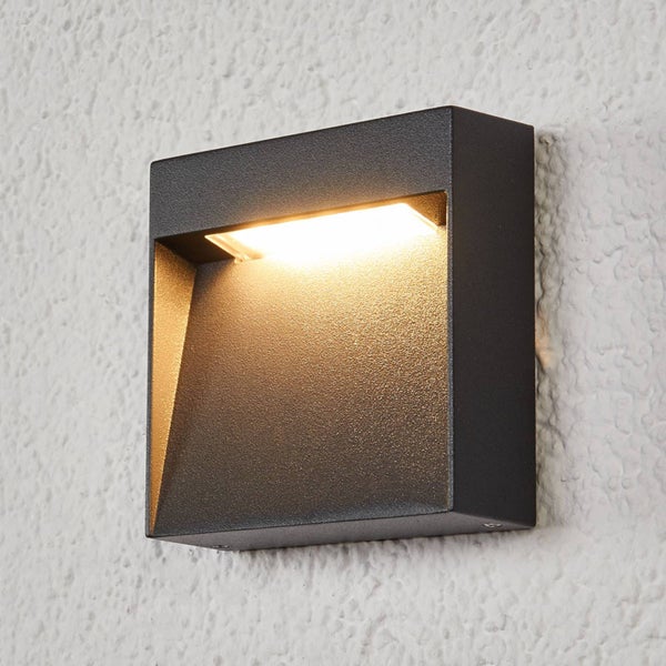 Quadratische LED-Außenwandleuchte in Anthrazit, eingeschaltet.