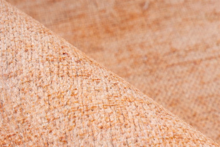 Nahaufnahme der strukturierten Oberfläche und des Webmusters eines gewebten Teppichs.