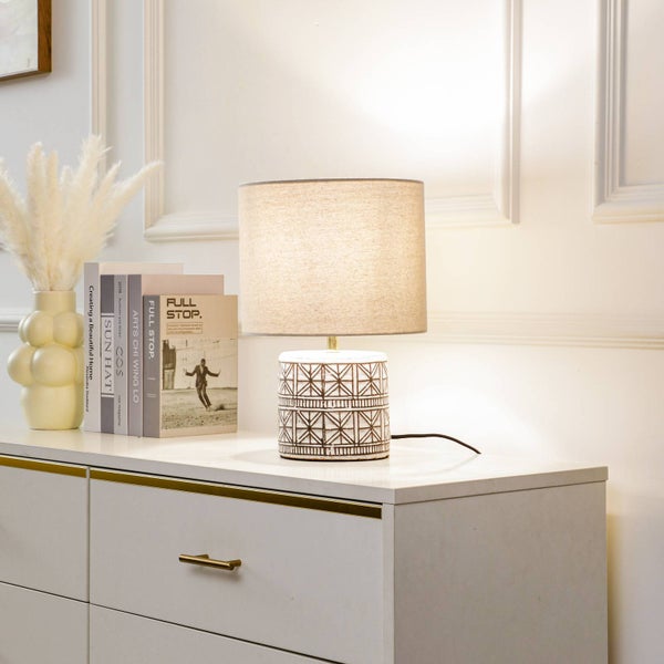 Dekorative Tischleuchte mit geometrischem Muster auf einem Sideboard