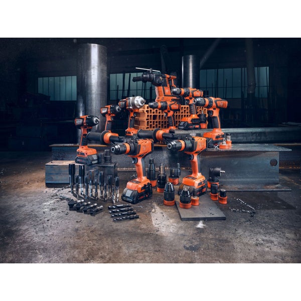 Eine Anordnung von Akku-Bohrmaschinen, Schraubern und Zubehör auf einer Werkbank in einer Werkstatt.