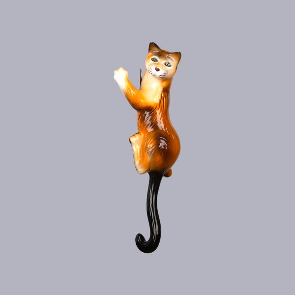 Braunes Wandthermometer in Katzenform mit glänzender Oberfläche.