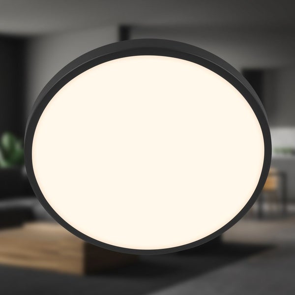 Runde LED-Deckenleuchte mit schwarzem Rahmen, beleuchtet in einem modern eingerichteten Wohnbereich.