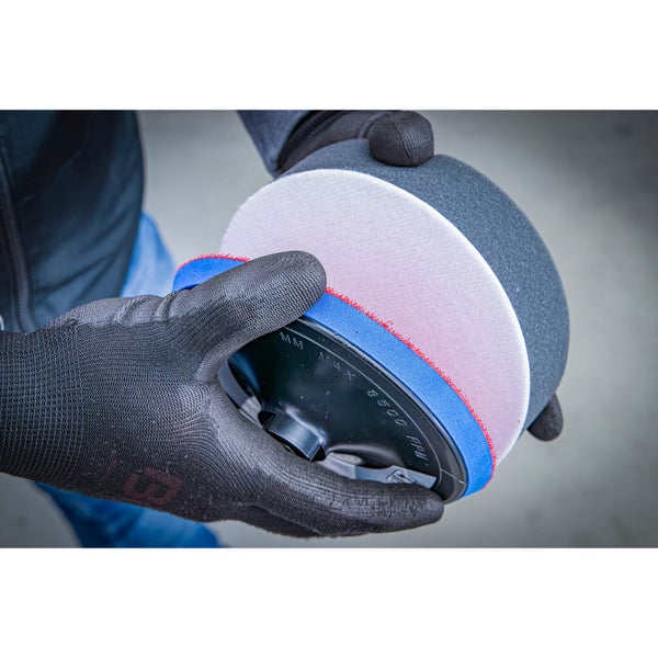 Polierteller mit Polierschwamm und Polierpad in der Hand