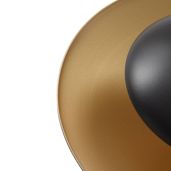 Detailaufnahme eines Lampenschirms mit goldfarbener Innenseite und schwarzer Außenseite.