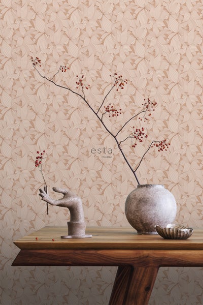 Einrichtungsbeispiel mit Tapete mit Blütenmuster, dekoriert mit Zweig, Vase und Handskulptur auf einem Holztisch.