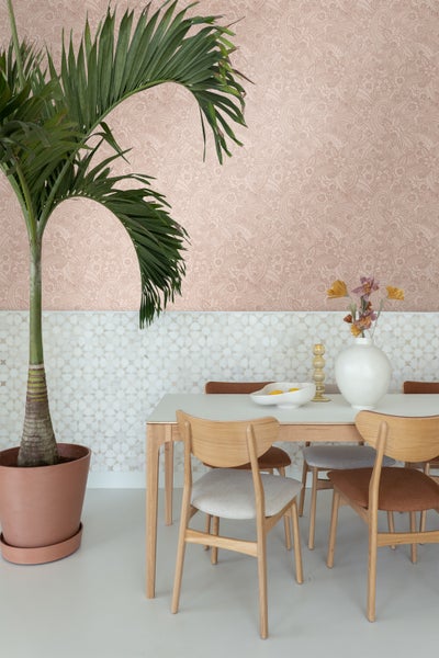 Esszimmer mit Tisch, Stühlen, Zimmerpflanze und dekorativer Wandgestaltung