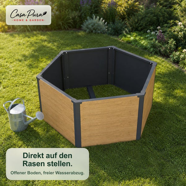 Sechseckiges Hochbeet in Holzoptik auf dem Rasen im Garten neben einer Gießkanne.