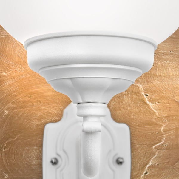 Weiße Außenwandleuchte im klassischen Design mit dekorativem Arm und rundem Lampenschirm.
