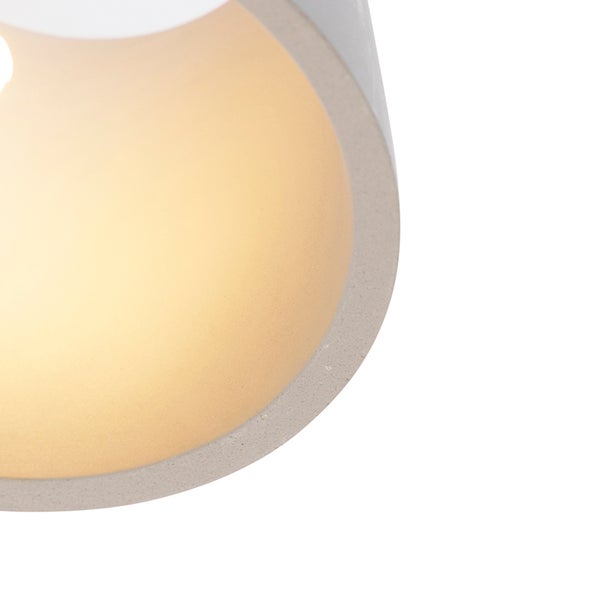 Nahaufnahme einer grauen Betonlampe mit eingeschaltetem Licht