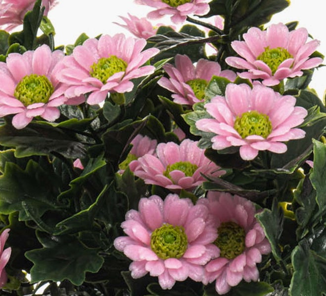 Künstlicher Strauß mit rosa Chrysanthemen und grünen Blättern.