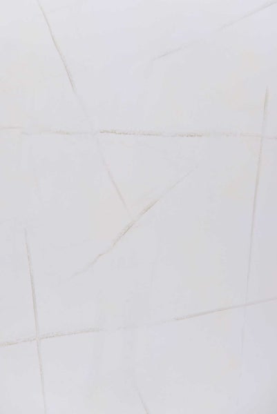 Weiße Feinsteinzeugfliese in Marmoroptik mit dezenten grauen Adern in einem geometrischen Muster.