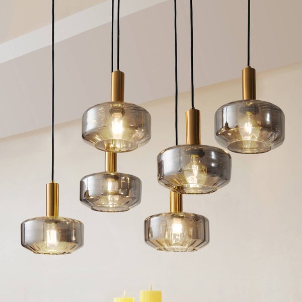 Moderne Hängeleuchte mit sechs runden Schirmen aus Rauchglas und goldfarbenen Fassungen an schwarzen Kabeln.