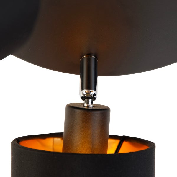 Nahaufnahme eines verstellbaren Gelenks einer Wandleuchte aus Metall mit schwarzem Stoffschirm.