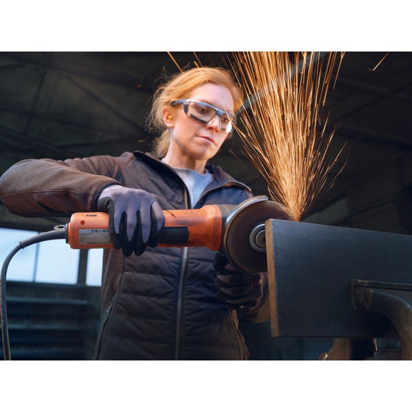 Frau schleift Metall mit Winkelschleifer, Funken fliegen