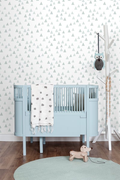 Kinderzimmer mit Gitterbett, Mobile, Teppich und Spielzeug