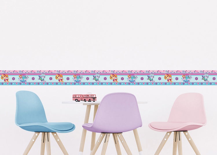 Tapetenbordüre mit Paw Patrol Motiven an einer weißen Wand in einem hellen Kinderzimmer mit Tisch und drei bunten Stühlen.