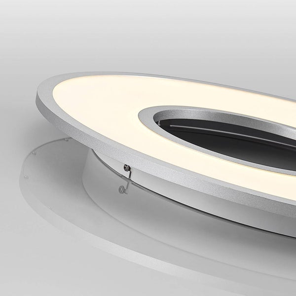 Nahaufnahme einer ringförmigen LED-Deckenleuchte mit silbernem Metallrahmen und warmweißem Licht.