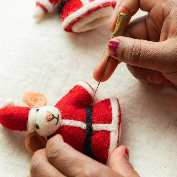 Filzmaus im Weihnachtsmannkostüm wird mit Nadel gefilzt