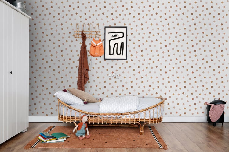 Kinderzimmer mit Rattanbett, Punktmuster-Tapete und dekorativen Accessoires für ein gemütliches Ambiente.