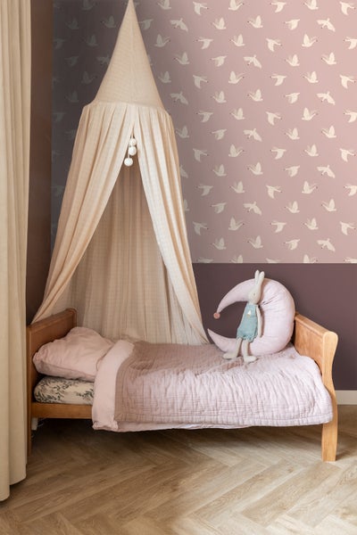 Kinderzimmer mit Bett, Baldachin und Tapete mit Vogelmuster für eine freundliche Atmosphäre
