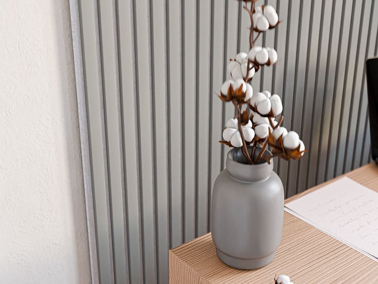 Moderne Wandverkleidung mit Lamellenoptik und eine Vase mit Baumwollzweigen auf einem Holztisch.