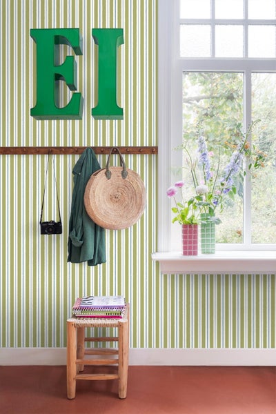 Interieuransicht eines Raumes mit gestreifter Tapete, Holzgarderobe und Fenster