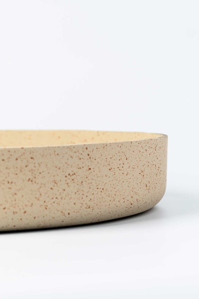 Detailansicht einer flachen Schale aus Keramik mit gesprenkelter Oberfläche.