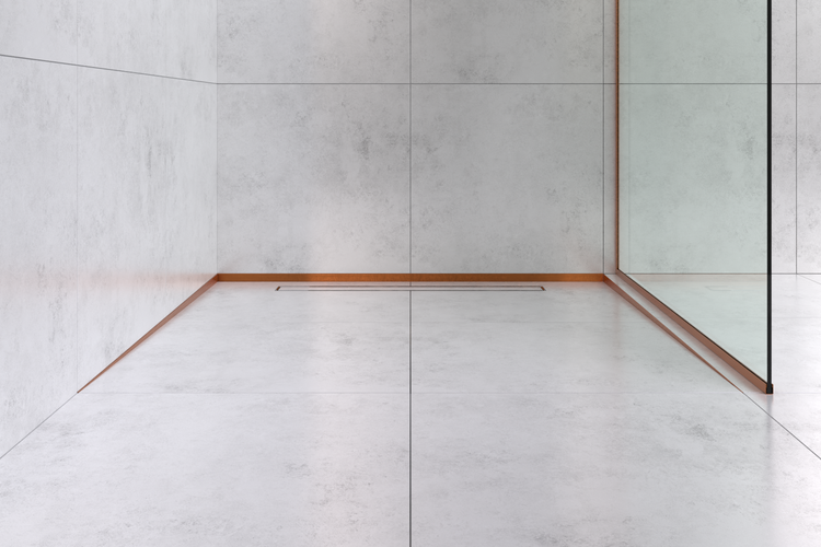 Bodengleiche Dusche mit hellgrauen Fliesen in Betonoptik, kupferfarbenem Abschlussprofil und Duschrinne.