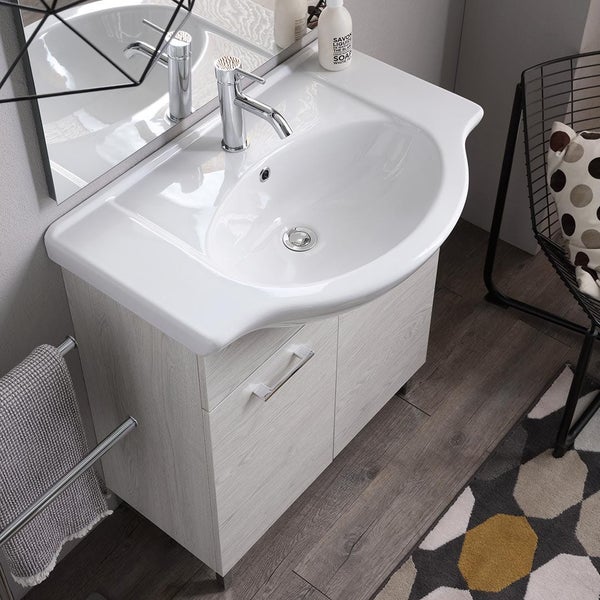 Moderner Waschtisch mit weißem Keramikbecken und Unterschrank in heller Holzoptik, inklusive verchromter Armatur im Badezimmer.