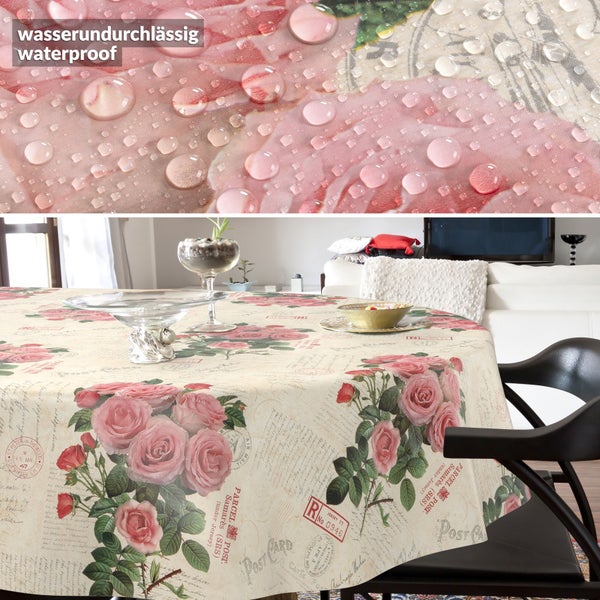 Wasserundurchlässige Tischdecke mit Rosen- und Postkartenmotiv auf rundem Tisch, Nahaufnahme zeigt wasserabweisende Oberfläche mit Wassertropfen.