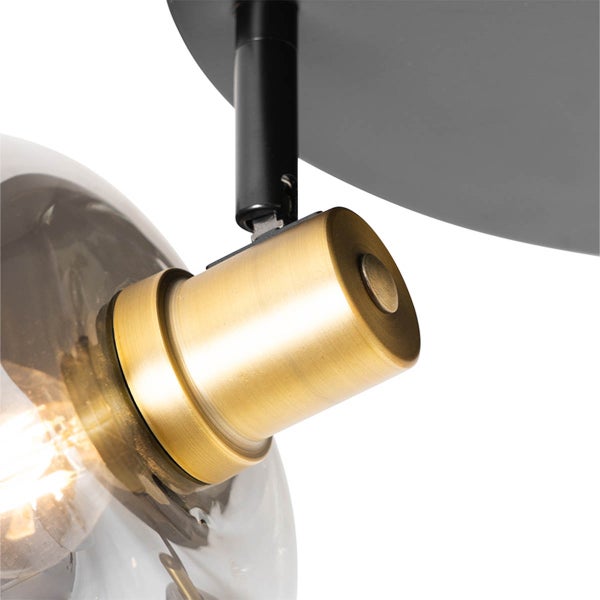 Nahaufnahme einer Deckenleuchte mit Lampenschirm aus Glas und Messingfassung