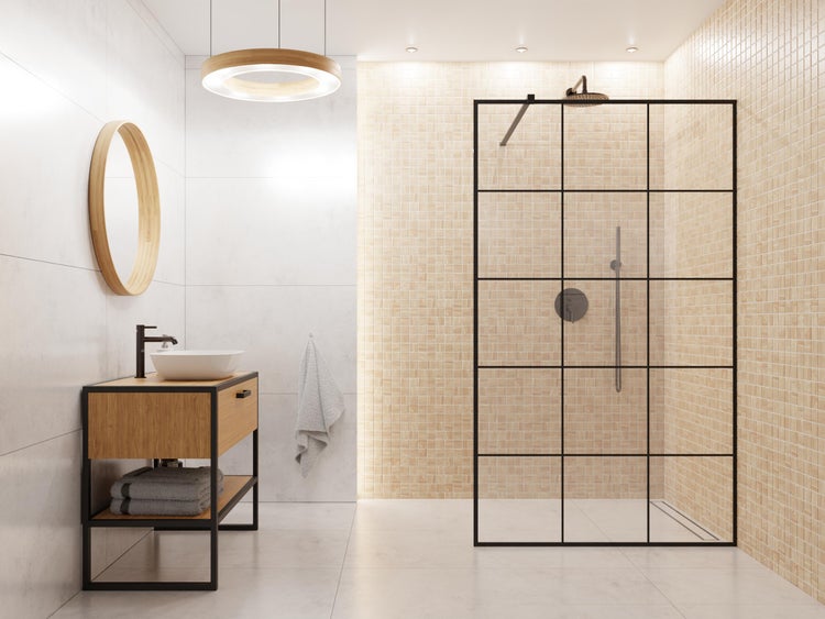 Modernes Badezimmer mit begehbarer Dusche mit schwarzem Sprossenrahmen, Waschtisch aus Holz mit Aufsatzbecken und rundem Holzspiegel.
