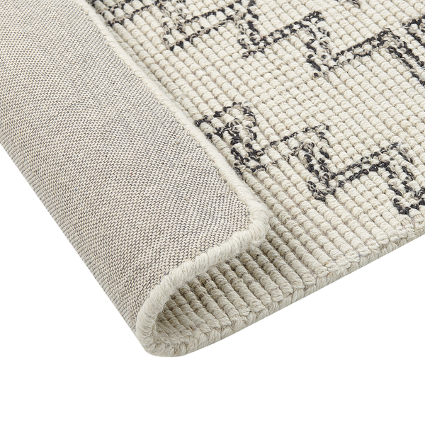Beiger flachgewebter Teppich mit dunklem geometrischem Muster, Detailansicht der gewebten Rückseite.