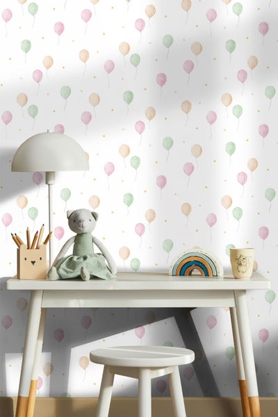 Kinderzimmer-Tapete mit Luftballon-Muster und Sternen hinter einem Schreibtisch mit Lampe und Spielzeug.