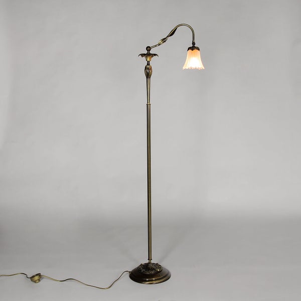 Stehlampe mit einem floralen Lampenschirm und einem verzierten, bronzefarbenen Gestell