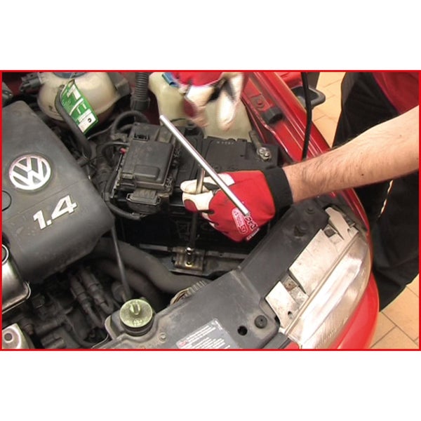 Motorraum eines Autos mit einer Person, die eine Autobatterie mit einem Schraubenschlüssel repariert