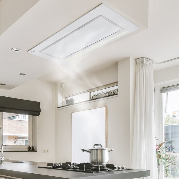 Helle, moderne Küche mit einer in die Decke integrierten Dunstabzugshaube über einem Kochfeld mit Edelstahltopf und aufsteigendem Dampf.