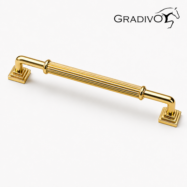 Goldfarbener Möbelgriff von Gradivo mit geriffeltem Design und abgestuften rechteckigen Sockeln. Gradivo Logo.