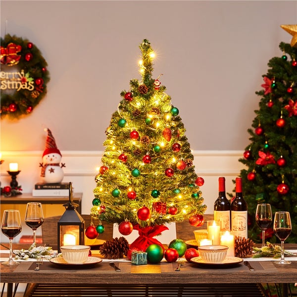 Dekorierter Tisch mit kleinem Weihnachtsbaum, Kugeln und Lichtern