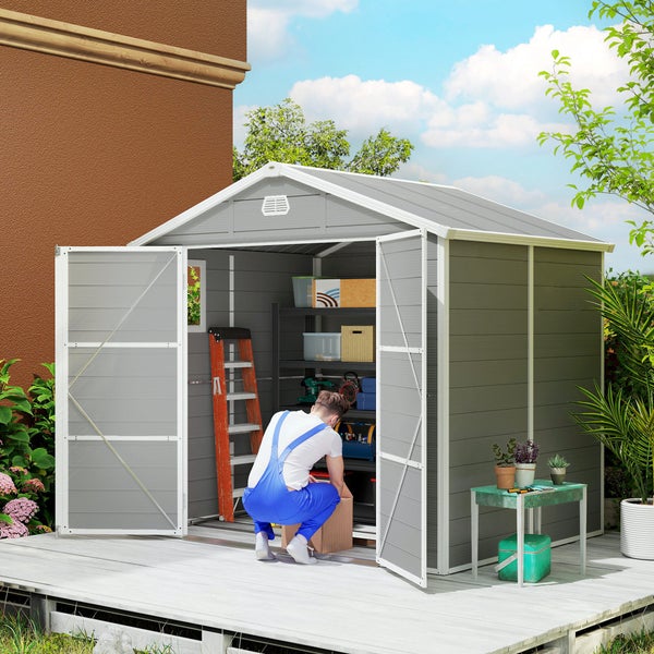 Terrassenüberdachung aus Metall an einer Hauswand montiert, schützt eine Sitzgruppe mit Polyrattan-Möbeln auf einer gepflasterten Terrasse.