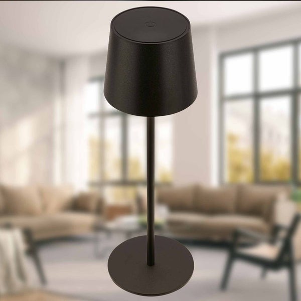 Schwarze Tischleuchte mit konischem Schirm und rundem Standfuß in einem hellen, modernen Wohnzimmer.