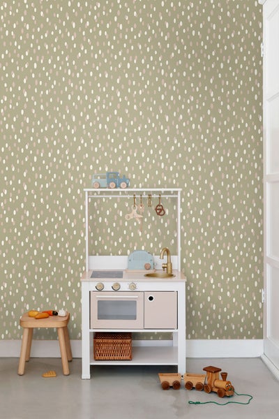 Kinderzimmer mit olivgrüner Tapete mit Punktmuster, Spielküche und Holzspielzeug
