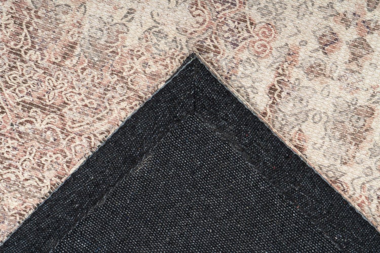 Teppich mit floralem Vintage-Muster und dunkler, gewebter Rückseite.