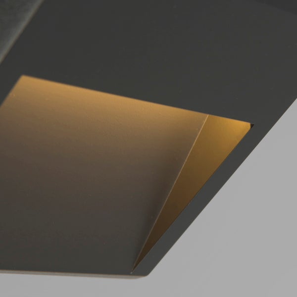 Detailansicht einer modernen Außenwandleuchte in Anthrazit mit warmweißem Lichtaustritt.