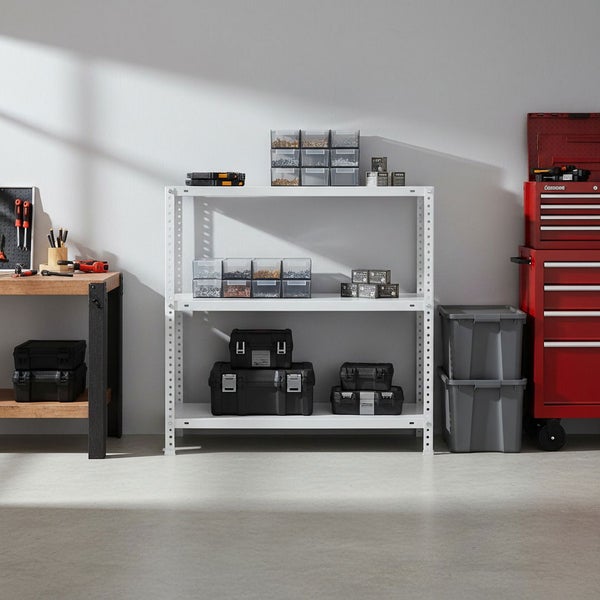 Hell und organisiert gestaltete Werkstatt mit weißem Metallregal, Werkzeugkoffern, Kleinteilemagazinen, Holzwerkbank und rotem Werkstattwagen.