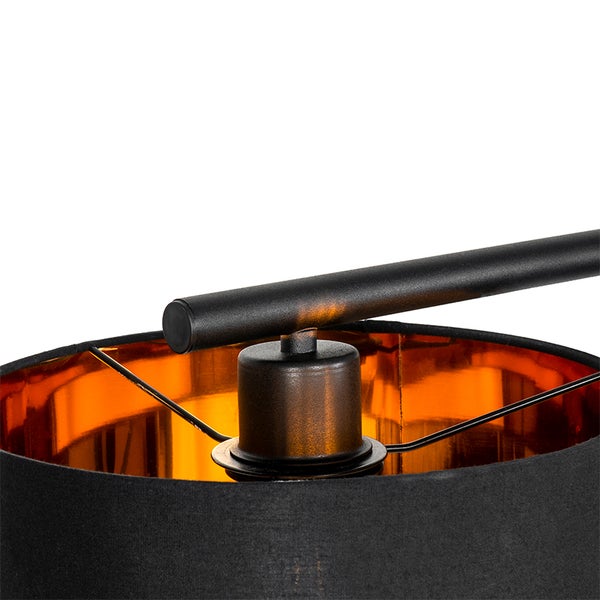 Detailaufnahme einer Lampe mit schwarzem Textilschirm und goldfarbener Innenseite.
