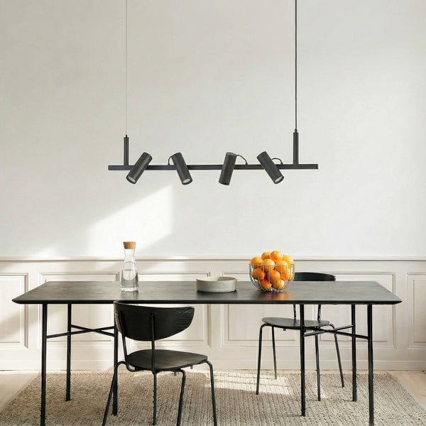 Esstisch mit Hängelampe mit Strahlern, Stühlen, Wasserkaraffe und Obstschale