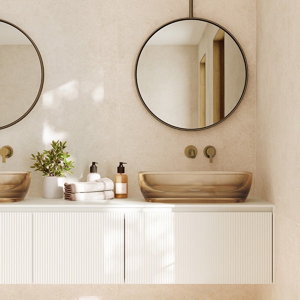 Modernes Badezimmer mit zwei runden Spiegeln, zwei Glaswaschbecken, Unterbauschrank mit gerippter Front und Wandarmaturen.