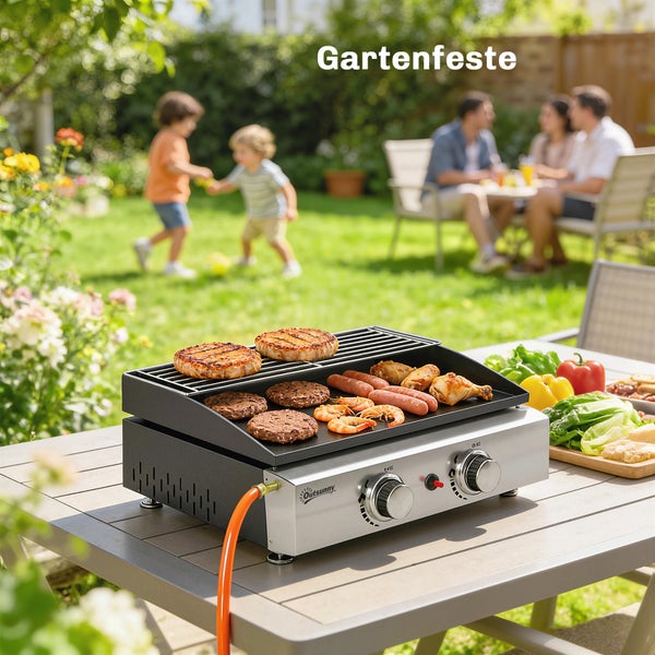 Heller Garten mit einem tragbaren Gasgrill aus Metall auf einem Holztisch, im Hintergrund feiernde Personen und spielende Kinder bei einem Gartenfest.