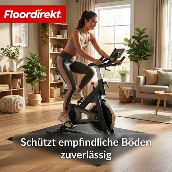 Frau trainiert auf einem Heimtrainer auf einer Bodenschutzmatte im Wohnzimmer